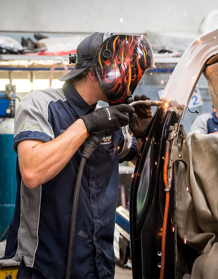 Col Wilkie Body Works team member welding section of car